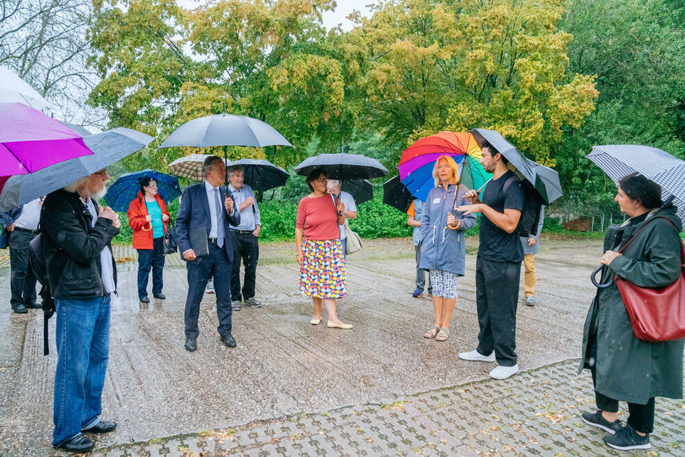 Menschen im Regen mit Schirmen