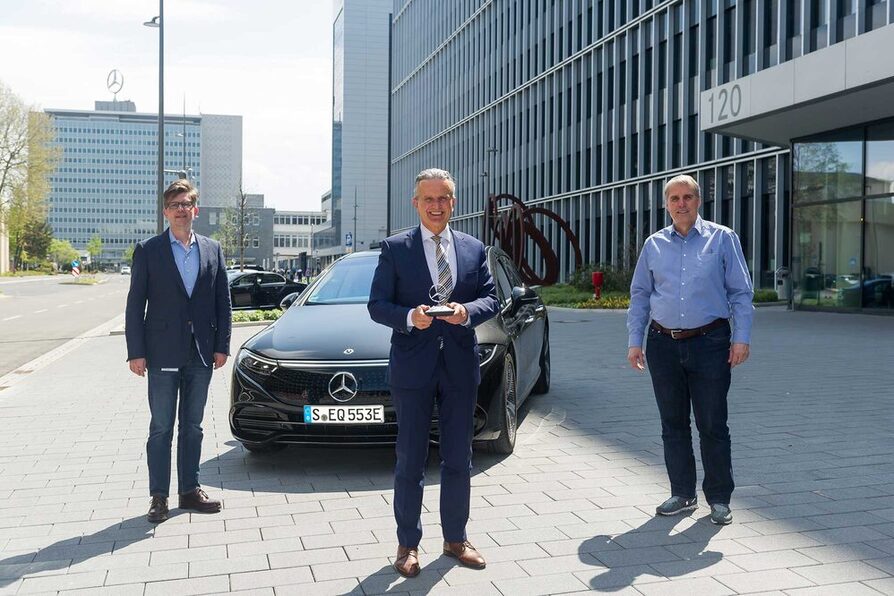 OB Dr. Frank Nopper steht vor dem neuen vollelektrischen EQS und hält einen Daimler-Stern in den Händen.