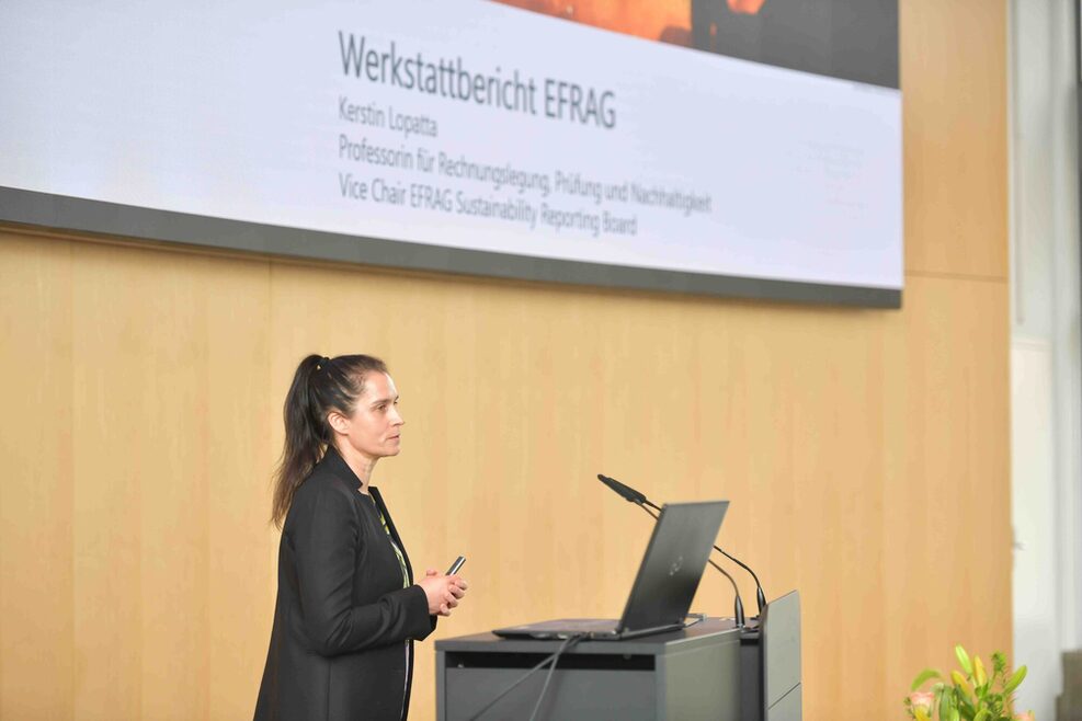 Prof. Dr. Kerstin Lopatta steht am Rednerpult und blickt in den Saal