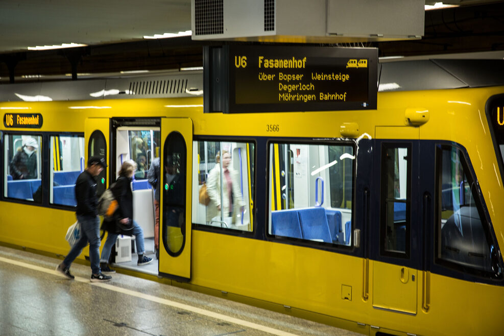 Stadtbahn der SSB hält an einer Haltestelle, Menschen steigen ein.