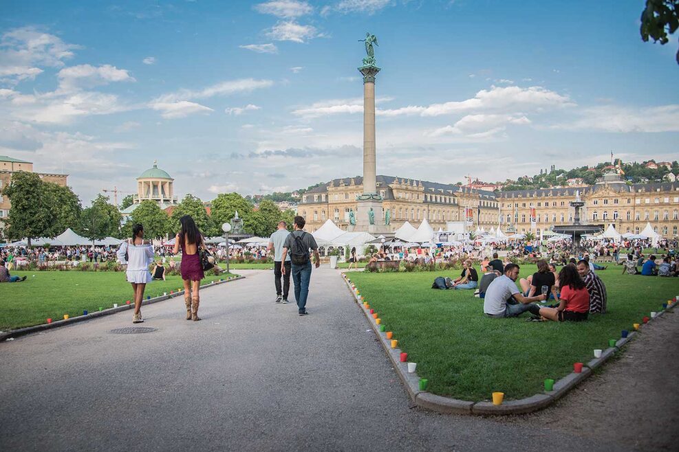 Schlossplatz im Sommert während des Sommerfestes. Zu sehen sind Menschen und weiße Pavillions des Sommerfestes.