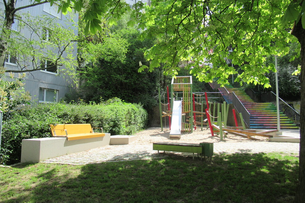 Der Spielplatz auf der dritten Ebene an der Danneckerstr. wurde grundlegend umgestaltet: neue Spielgeräte, Sitzgelegenheiten und eine Absicherung gegen einfahrende Autos. Die Treppe wurde in leuchtenden Farben bemalt.