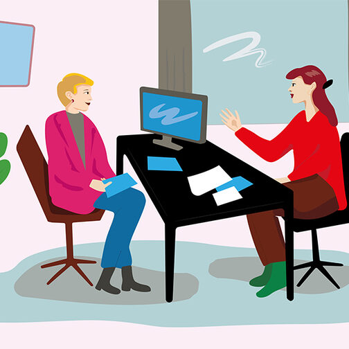 Das Bild zeigt eine Beratungssituation in einem Büro. Zwei Frauen sitzen sich an einem Schreibtisch gegenüber.