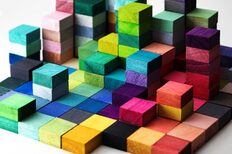 Bunte, unterschiedlich hohe Holzklötze in vielen Farben, die symbolisch die Vielfalt moderner Familienformen darstellen.