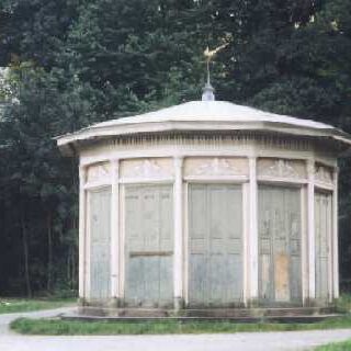 ein runder Pavillon mit einem kleinen goldenen Fasan auf dem Dach