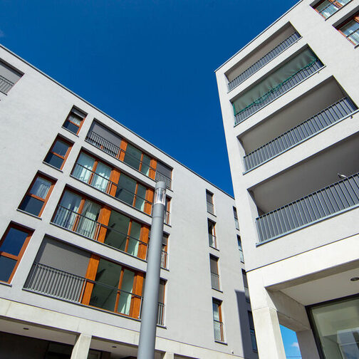 Blick nach oben auf die Außenfassade zweier Neubauten.