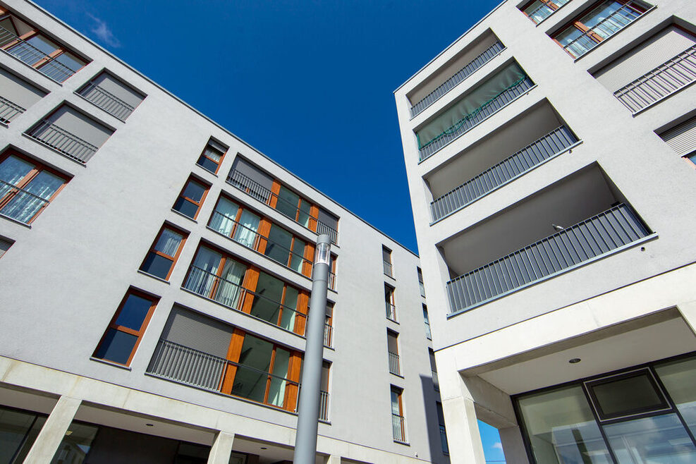 Blick nach oben auf die Außenfassade zweier Neubauten.