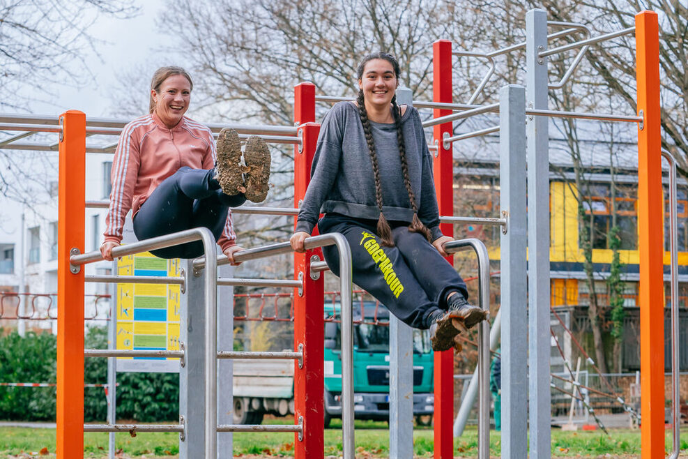 Zwei junge Frauen nutzen die Calisthenicsanlage in Stuttgart-Vaihingen