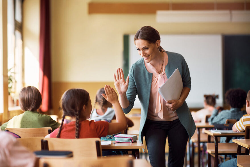 Eine Lehrerin läuft durch ihre Schulklasse.