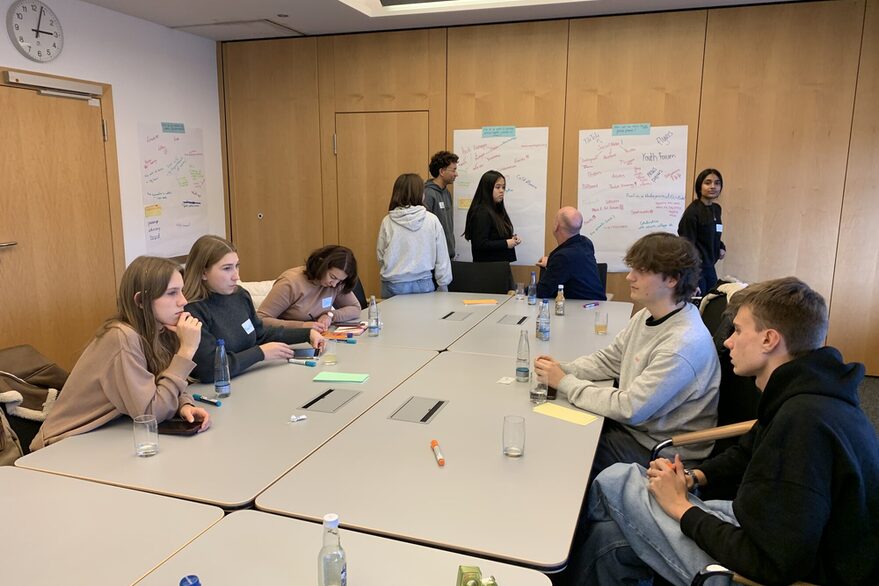 Jugendräte aus den Partnerstädten sitzen bei einem Workshop zur Jugendbeteiligung im Rathaus gemeinsam am Tisch und erarbeiten Ideen.