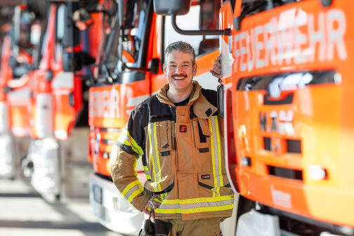 Feuerwehrmann lacht freundlich in die Kamera