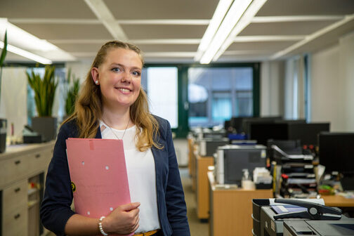 Junge Frau mit blauem Blazer lächelt in die Kamera