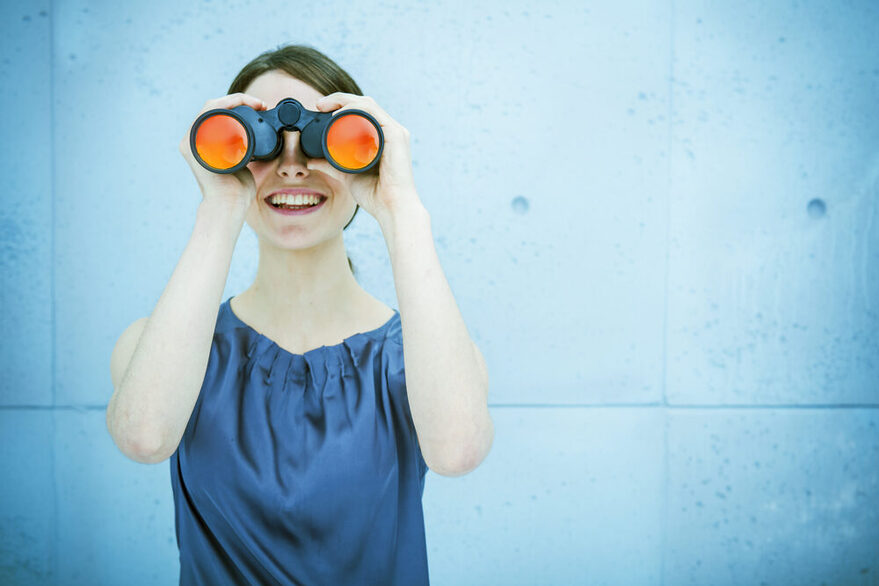 Businesswoman holding binoculars