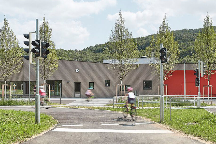 Neubau der Jugendverkehrsschule „Westbahnhof“: Kinder fahren auf dem Fahrrad über eine Straße mit Ampel.