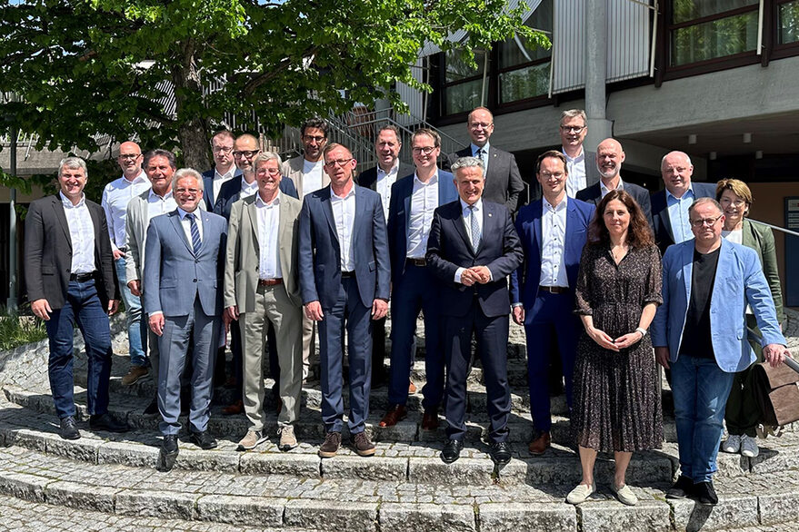 Die Oberbürgermeister der Region Stuttgart stehen auf einem Platz und schauen freundlich in die Kamera.