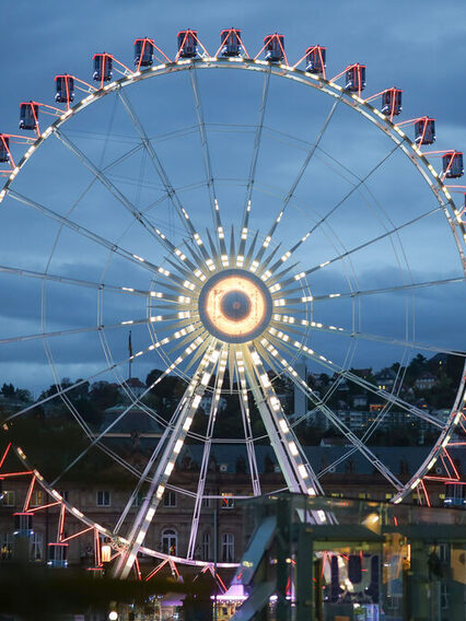 Das Riesenrad auf dem Schlossplatz leuchtet in der Dämmerung.