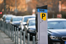 Ein Parkscheinautomat auf einem Gehweg in Stuttgart-Mitte. Am Rand parken Autos.