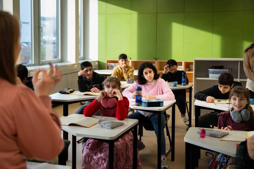 Kinder sitzen in einem Lernraum