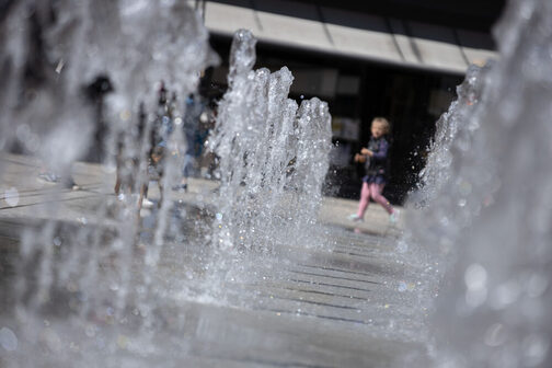 The fountain field on Stuttgart's market square can be seen in the foreground, with a child playing in the background.