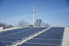 Im Vordergrund ist die Photovoltaik der Eiswelt zu sehen, im Hintergrund der Fernsehturm.