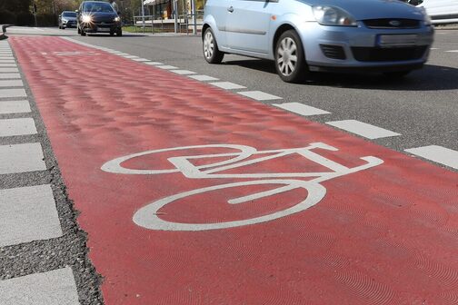 Roter Radstreifen in der Böblinger Straße im Vordergrund und fahrende Autos im Hintergrund.