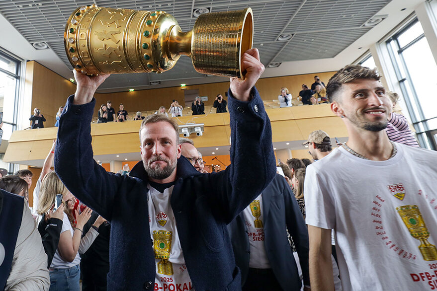 Das Foto zeigt den Trainer des VfB Stuttgart Sebastian Hoeneß mit dem Pokal, daneben Kapitän Atakan Karazor, beim Einlauf zum Empfang im Stuttgarter Rathaus.