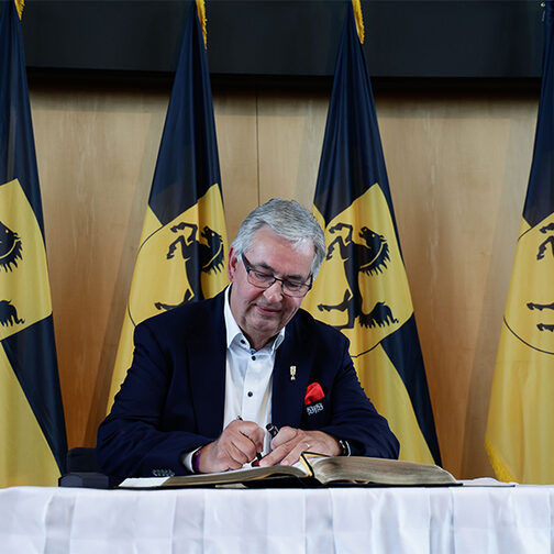 Das Foto zeigt den Präsidenten des VfB, Dietmar Allgaier, wie er sich ins Goldene Buch der Landeshauptstadt einträgt. Foto: Leif Piechowski/Stadt Stuttgart