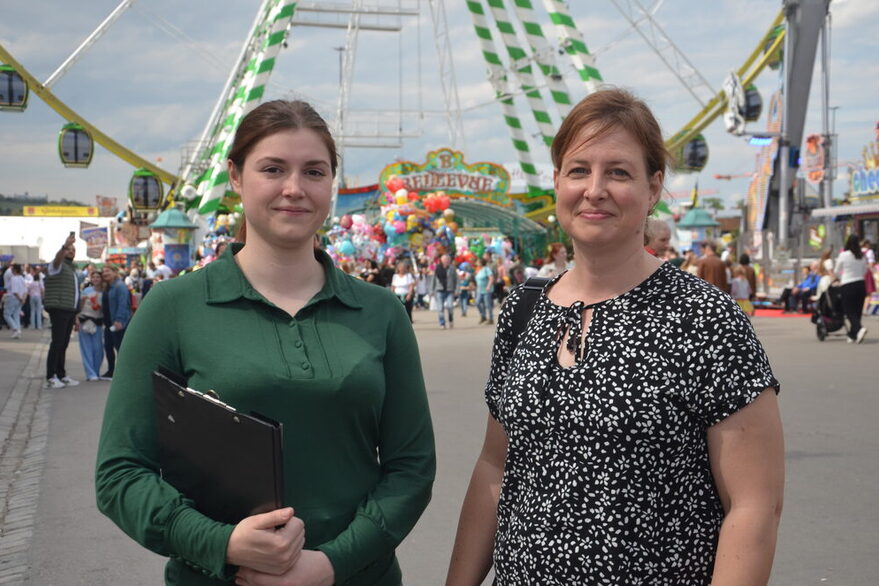 Die beiden Lebensmittelkontrolleurinnen auf dem Frühlingsfest, mit dem Riesenrad im Hintergrund.