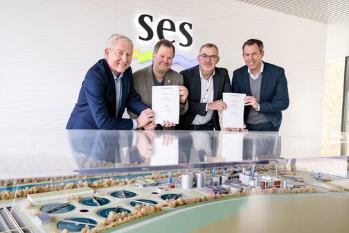 Gruppenfoto von Martin Braunersreuther, Geschäftsführer Phosphorgewinnung Schkopau, Dr. Christian Kabbe, Geschäftsführer EMG EasyMining Germany, Jürgen Mutz, Amtsleiter Tiefbauamt mit Eigenbetrieb Stadtentwässerung (SES) und Stephen Kemper, Bereichsleitung Stadtentwässerung im Tiefbauamt der Stadt Karlsruhe vor einem Modell des Geländes der Stadtentwässerung Stuttgart.