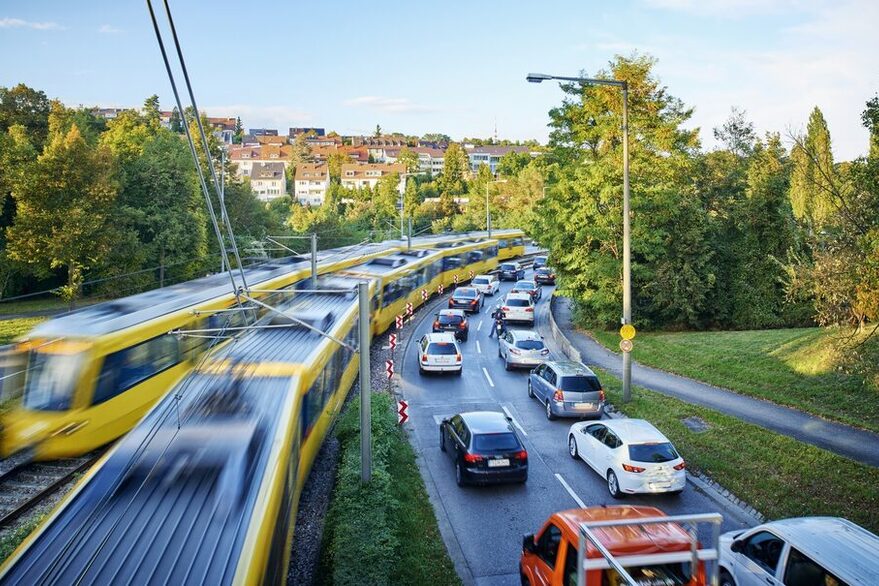 SSB-Bahnen fahren an einem Autostau vorbei.