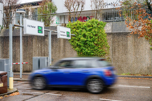 A blue compact car drives up to the barrier of a park and ride parking lot on Albstraße in Degerloch.