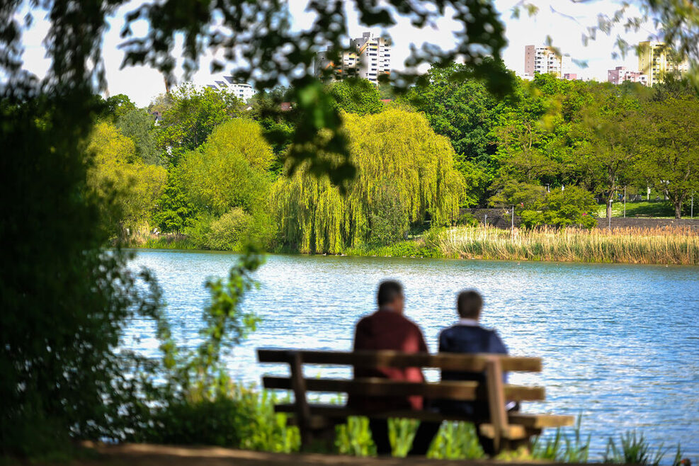 Zwei Personen sitzen auf einer Bank am Max-Eyth-See