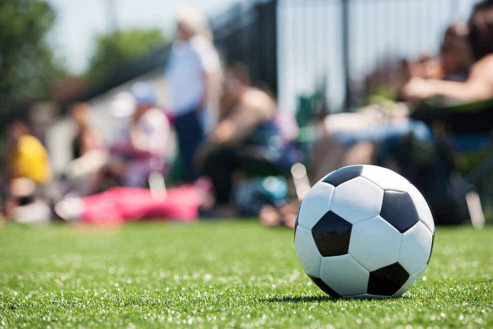 Fußball auf dem Rasen im Hintergrund Publikum.
