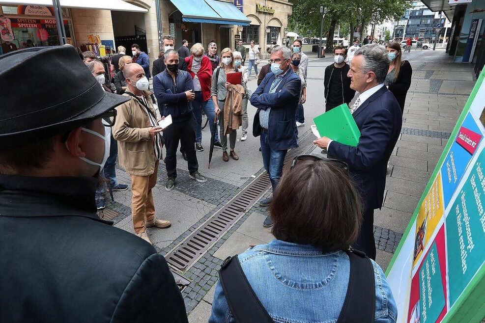Oberbürgermeister Dr. Frank Nopper steht in der Fußgängerzone in Bad Cannstatt. Um ihn herum Bürgerinnen und Bürger, die das Gespräch suchen.