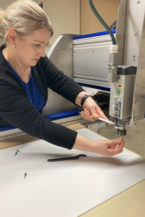 Karin Haberer setzt einen Gravierstichel in die CNC-Fräse.