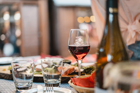 Glas Rotwein auf gedecktem Tisch