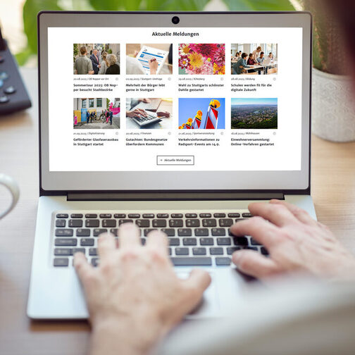 Mann sitzt vor einem Laptop am Schreibtisch mit Kaffeetasse