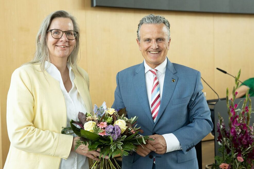 Andrea Münch (links) hält einen Blumenstrauß, Frank Nopper (rechts) im GRoßen Sitzungssaal im Rathaus.