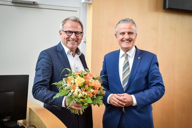 Udo Lutz mit einem Blumenstrauß, rechts neben ihm steht Oberbürgermeister Dr. Frank Nopper