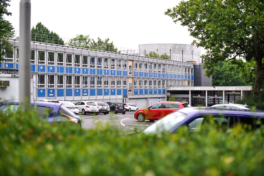 Blick auf das Gebäude der Zulassungsstelle in der Krailenshaldenstraße: Vor dem Gebäude stehen Autos auf einem Parkplatz.
