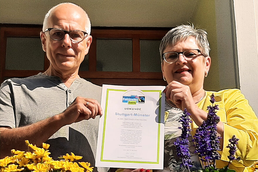 Von links: Rainer Gehring, Sprecher Steuerungsgruppe Fairtrade und Bezirksvorsteherin Renate Polinksi halten die Fairtrade-Urkunde in der Hand.