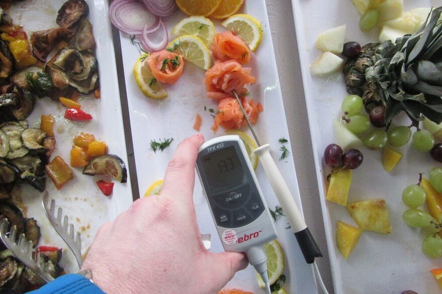 Ein Lebensmittelkontrolleur überprüft die Temperatur von Lachshäppchen.