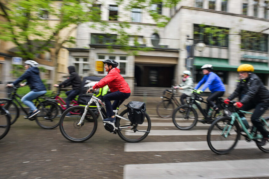 Mehrere Menschen fahren Fahrrad auf einer Straße