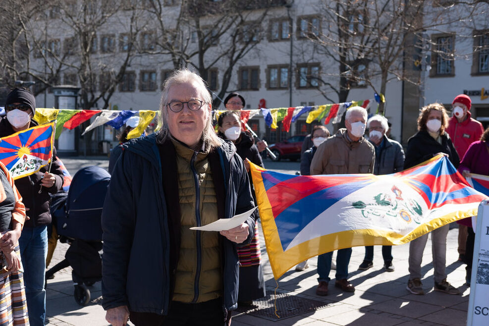 Bürgermeister Peter Pätzold steht vor Vertretern der Regionalgruppe Stuttgart der Tibet Initiative Deutschland (TID). Diese halten eine Tibet-Flagge in Händen.