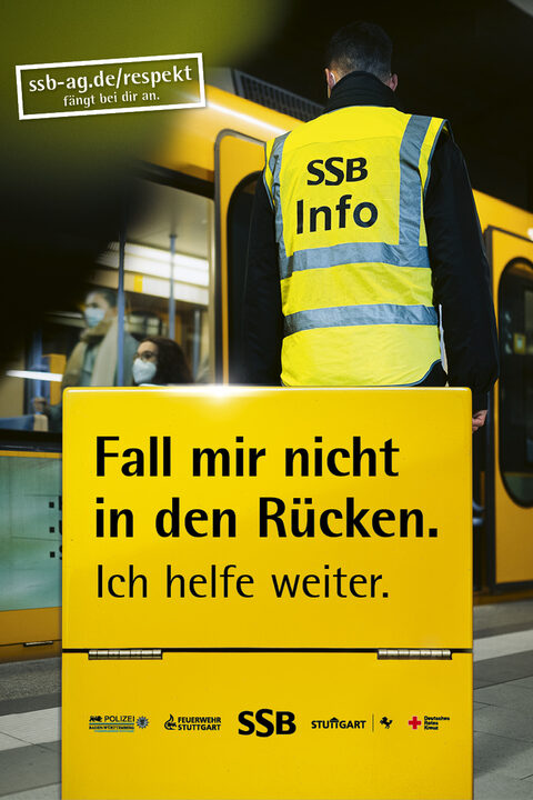 Plakat mit der Aufschrift "Fall mit nicht in den Rücken". Im Hintergrund ist ein Mitarbeiter der SSB an einem Bahnsteig zu sehen.