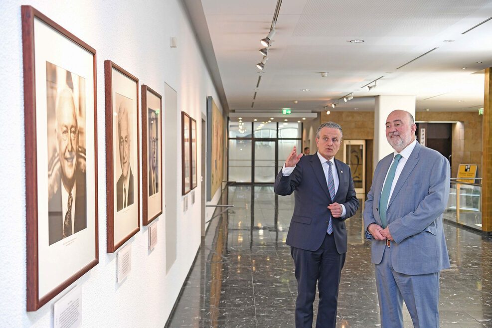 Stuttgarts Oberbürgermeister Dr. Frank Nopper (links) führt Israels Botschafter Ron Prosor durch das Rathaus. OB Nopper zeigt Ron Prosor die Portraitfotos der ehemaligen Stuttgarter Oberbürgermeister, die im 1. Stock im Rathaus hängen.