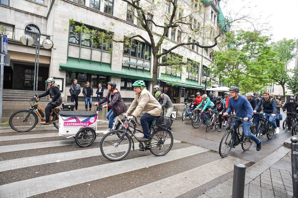 Eine Gruppe von Radfahrerinnen und Radfahrer fährt über einen Zebrastreifen in der Eberhardstraße.