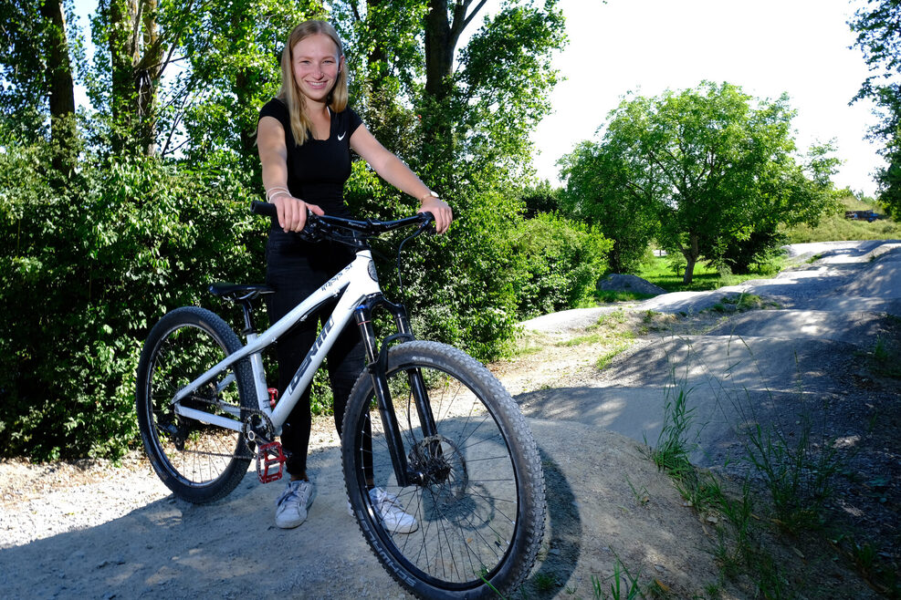 junge Frau mit Mountainbike am Pumptrack