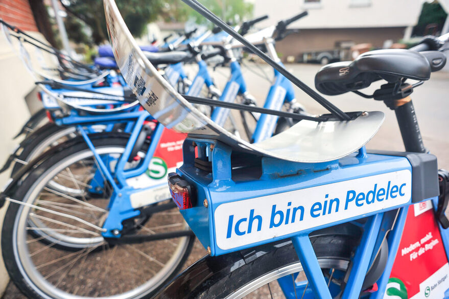 Eine Verleihstation von Regio-Rad-Stuttgart: Mehrere blaue Fahrräder mit einem elektrischen Motor stehen nebeneinander.