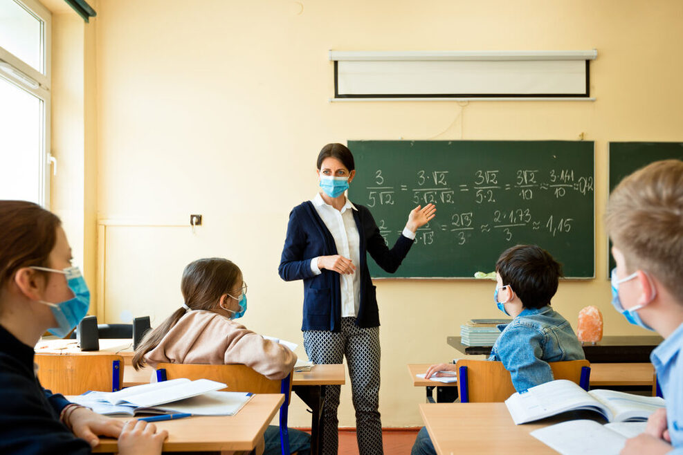 Eine Lehrerin unterrichtet vor einer Schulklasse